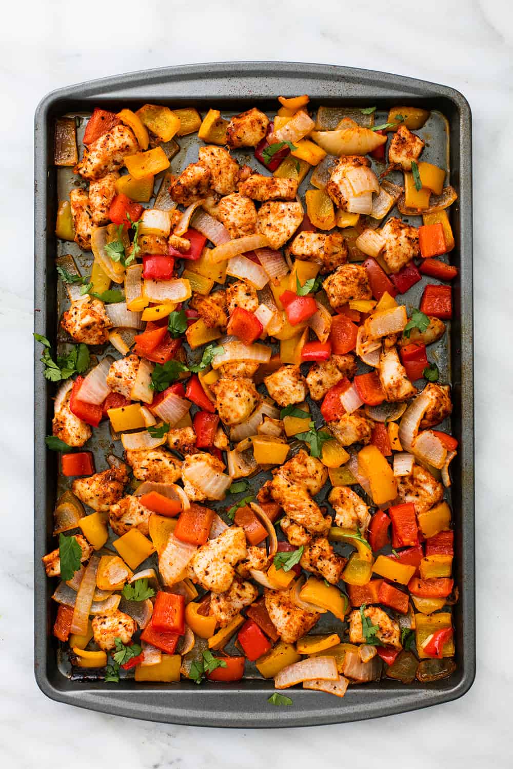 One Pan Fajita Chicken and Veggies is an awesome meal in one with zesty lime and spicy seasonings. Ready in under 30 minutes this meal will be one of the best you have tried! Areal view of a sheet pan cajun chicken.