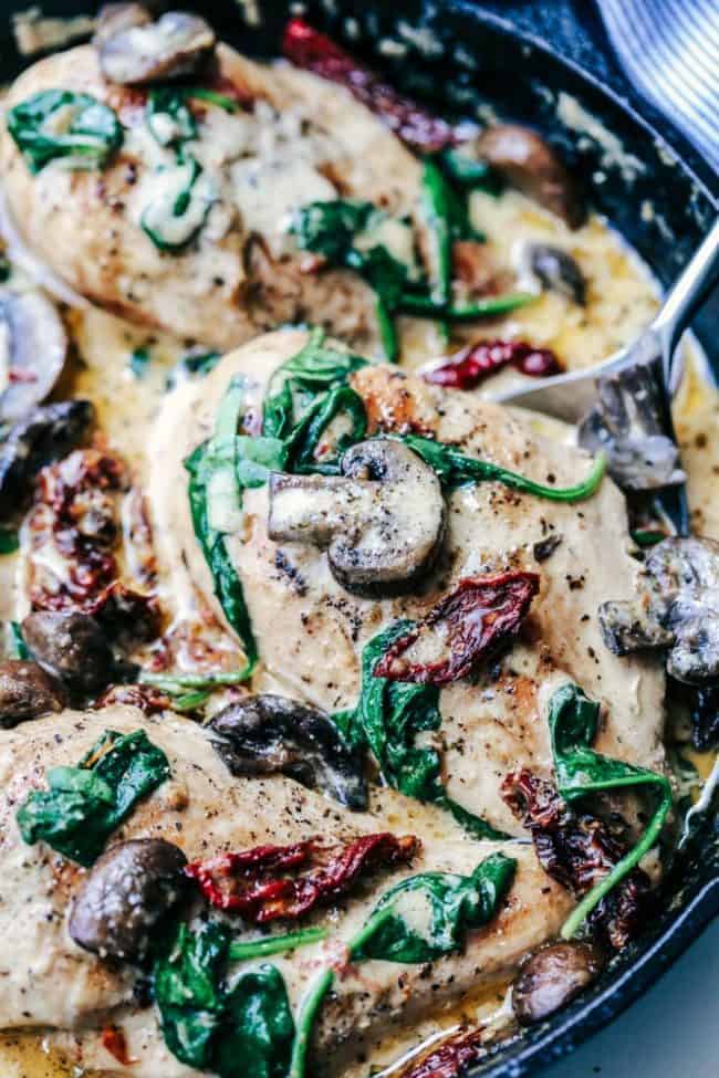 Skillet Creamy Chicken Mushroom Florentine is a fantastic restaurant quality meal that you can make for your family in less than 30 minutes!! You will not find a better creamy white sauce on top of this tender and juicy chicken. Skillet Creamy Chicken Mushroom Florentine in a skillet.