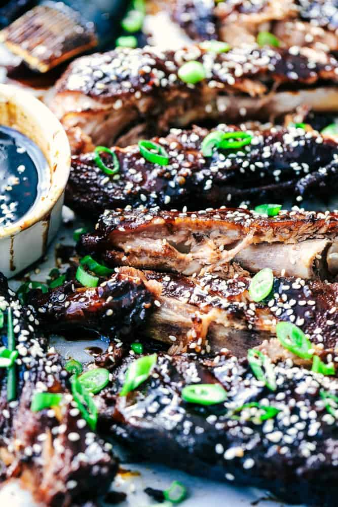 Slow Cooker Sticky Asian Ribs with Sticky Sauce are the very best fall of the bone tender ribs you will ever make! Slow cooked to perfection in a sweet and tangy asian sauce. They get slathered right before serving in a finger licking good sticky sauce! Slow Cooker Sticky Asian Ribs with Sticky Sauce close up.