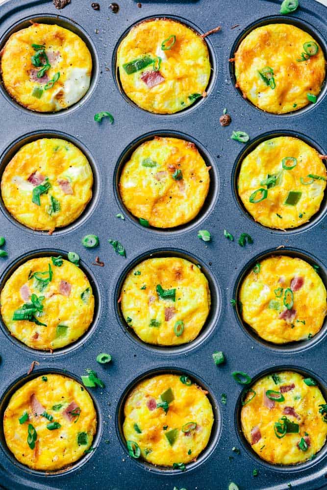 Denver Omelet Breakfast Muffins are such a great breakfast and perfect for making ahead or on the go! Loaded with Peppers, onions, ham and ooey gooey cheese, these will become a favorite! Denver Omelet Breakfast Muffins areal view in rows in a muffin pan.