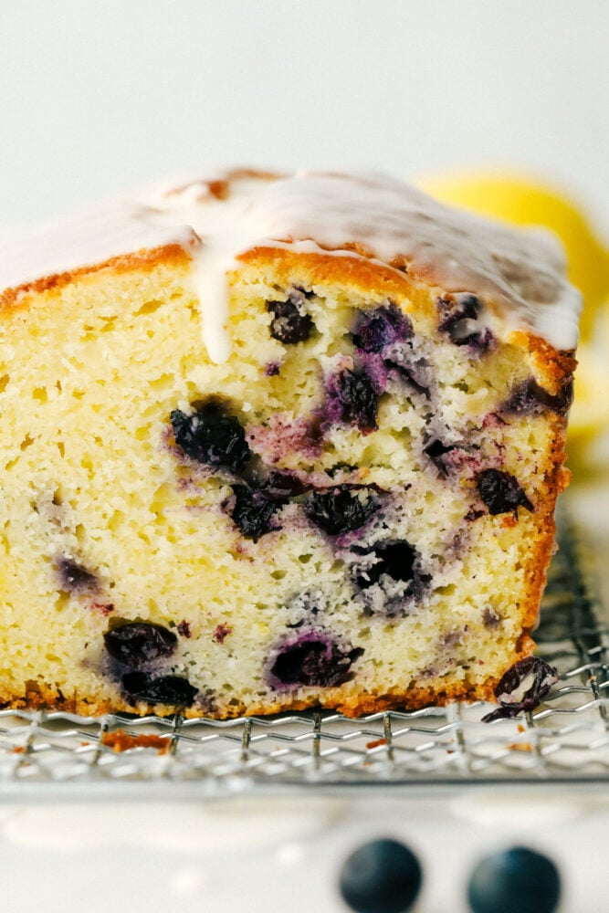 Blueberry Lemon Pound Cake! ย This pound cake is made lighter by using greek yogurt, and is loaded up with lemon flavor thanks to zest and fresh lemon juice! Juicy blueberries are baked right in. All drizzled with a luscious lemon glaze.ย The cross section of the blueberry lemon cake.