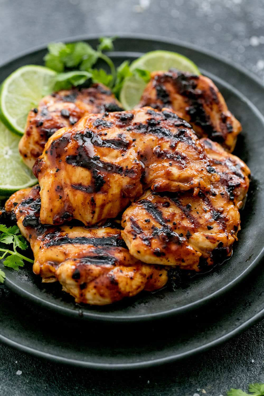 Grilled Chili Lime Chicken is made with tender and juicy grilled chicken with the best chili lime marinade! This is one that your family will love! Grilled Chili Lime Chicken on a black plate.