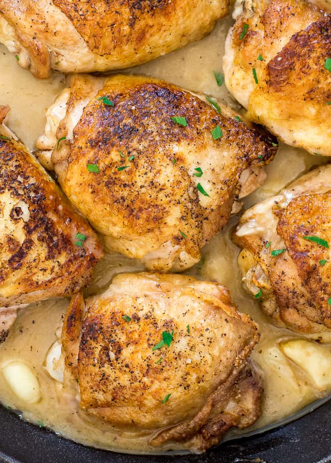 Chicken with 40 Cloves of Garlic. Juicy and tender chicken thighs pan fried and served with tons of garlic and an amazing sauce! Cooked chicken close up.