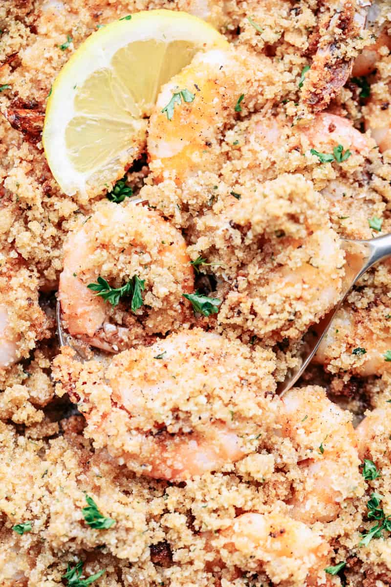 Crunchy Baked Parmesan Garlic Shrimp is buttery and delicious parmesan garlic shrimp coated and baked to crispy crunchy perfection. The flavor is incredible and you won't be able to get enough! Crunchy Baked Parmesan Garlic Shrimp close up on a spoon.