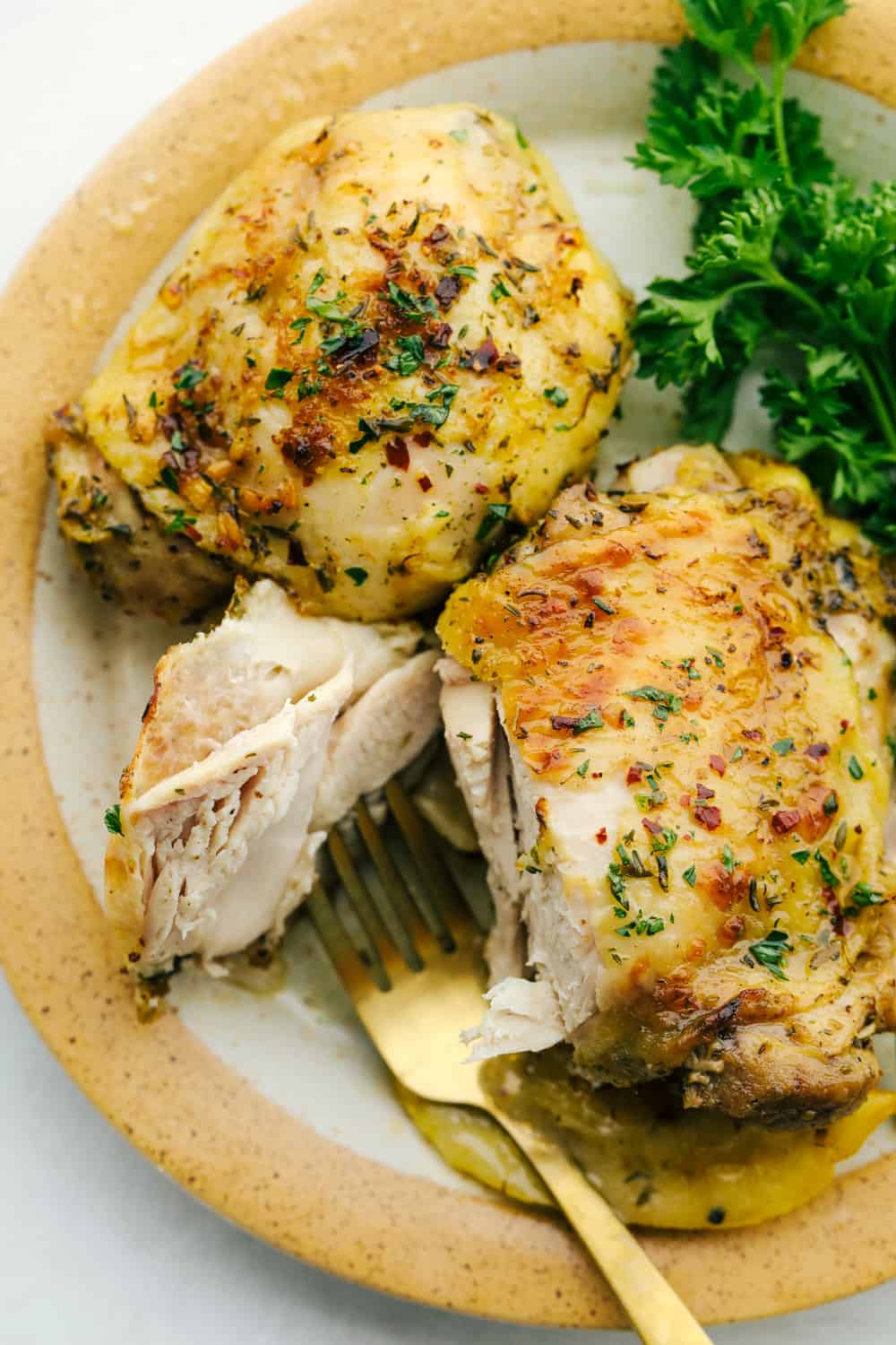 Easy Greek Lemon Chicken is trip to flavortown in a one pan dish. Greek Chicken is made with a handful of ingredients that make an easy pan sauce. Greek Lemon chicken on a plate, and cut by a fork.