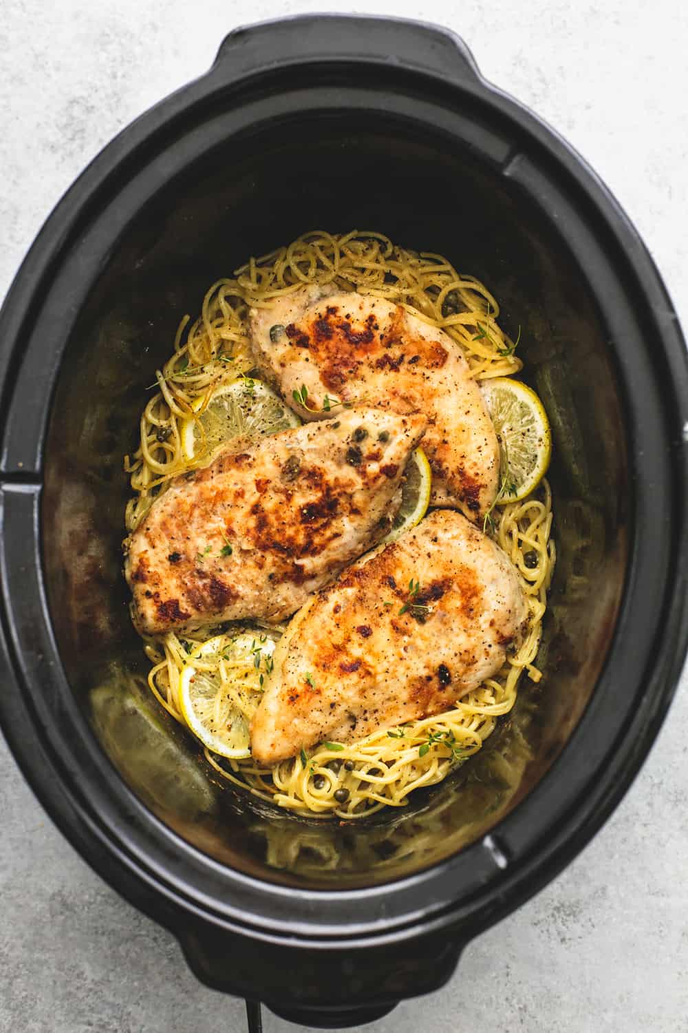 Slow Cooker Lemon Chicken Piccata is creamy lemony sauce-coated noodles with juicy lightly breaded chicken with a hint of garlic, all topped with savory capers! Lemon Chicken Piccata in a slow cooker.