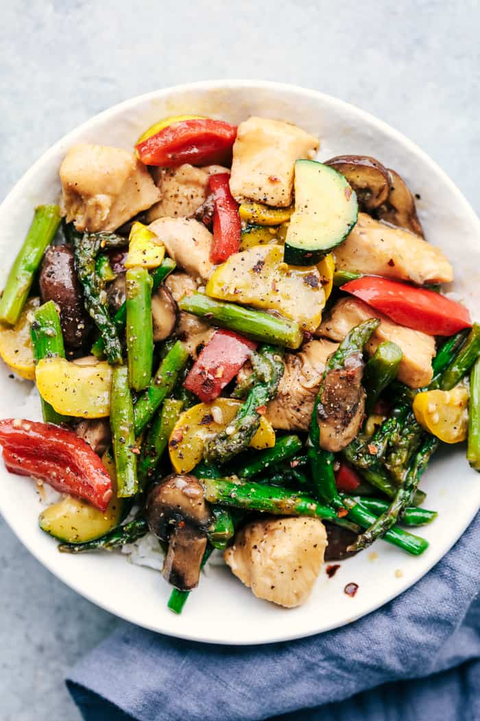 Honey Garlic Chicken Stir Fry is such a delicious one pan meal filled with veggies and chicken and coated in a delicious and savory honey garlic sauce. This is an easy 30 minute meal that your family will love! Honey Garlic Chicken Stir Fry on a white plate.