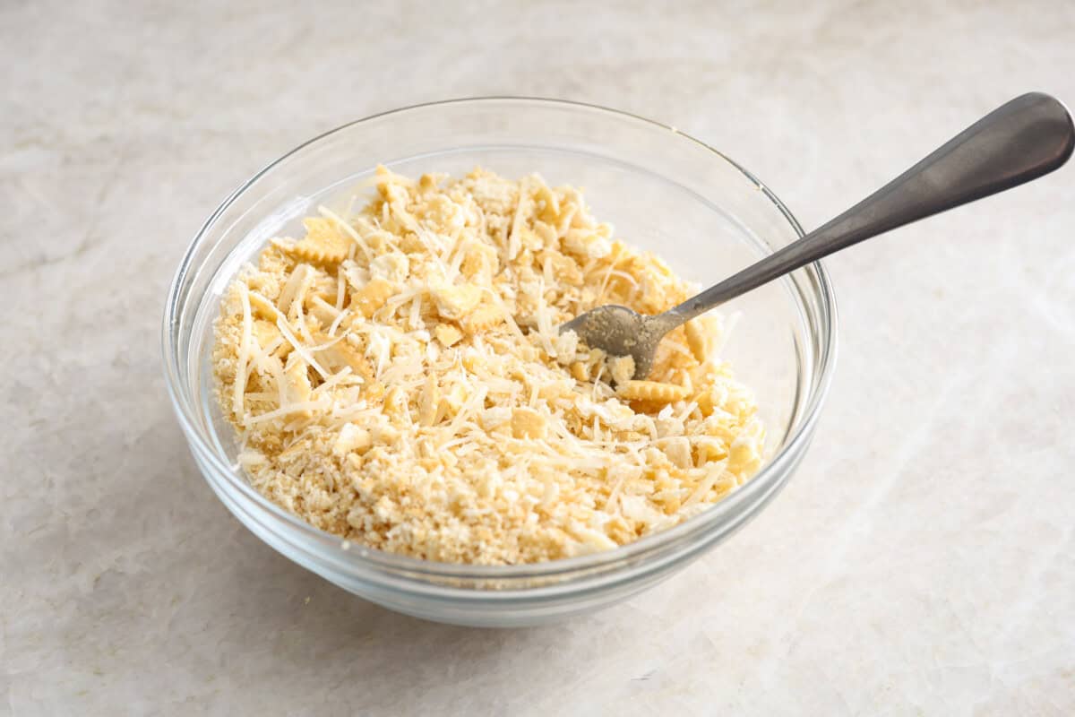 cooked chicken, corn, cream of chicken soup, milk, sour cream, onion flakes, Italian seasoning, garlic powder, salt, pepper, and cheddar cheese. Overhead shot of the crushed Ritz crackers butter and cheese in a bowl.