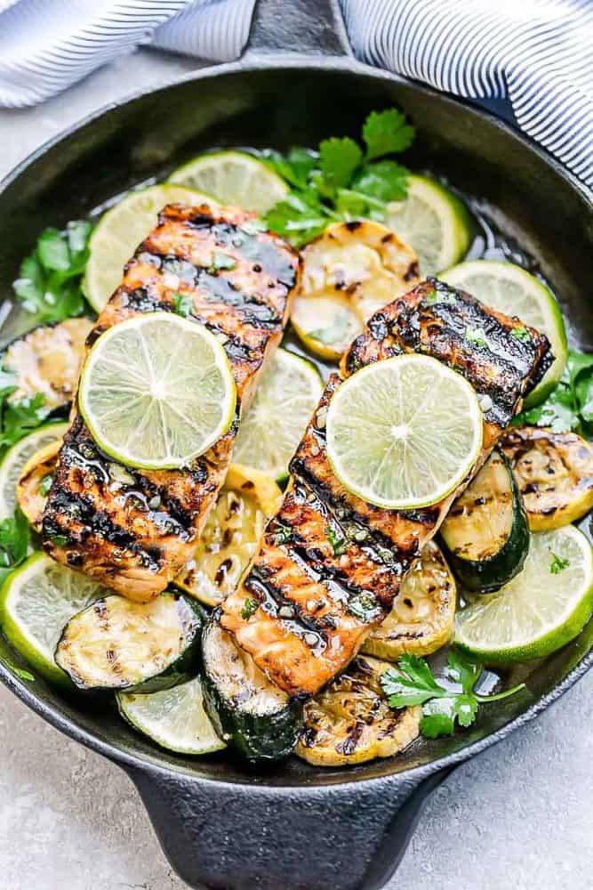 This Grilled Honey Lime Salmon is a light and tasty dish that is just perfect for summer. The honey and lime butter sauce is sweet, tangy and so amazingly flavorful! This Grilled Honey Lime Salmon in a black skillet.