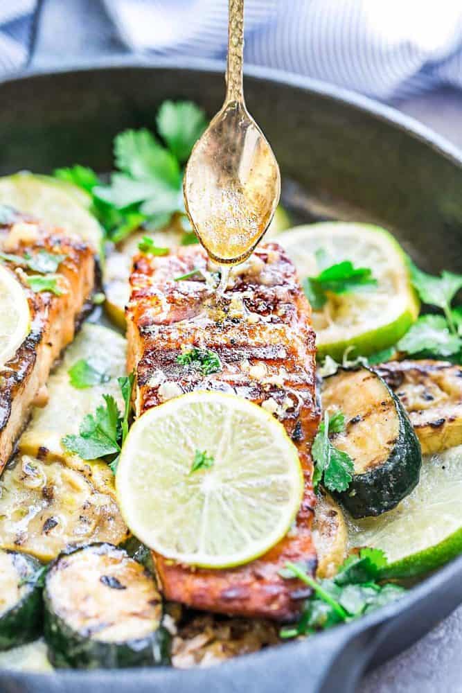 This Grilled Honey Lime Salmon is a light and tasty dish that is just perfect for summer. The honey and lime butter sauce is sweet, tangy and so amazingly flavorful! This Grilled Honey Lime Salmon in a black skillet.