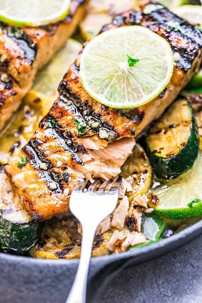 This Grilled Honey Lime Salmon is a light and tasty dish that is just perfect for summer. The honey and lime butter sauce is sweet, tangy and so amazingly flavorful! This Grilled Honey Lime Salmon being pulled apart with a fork.