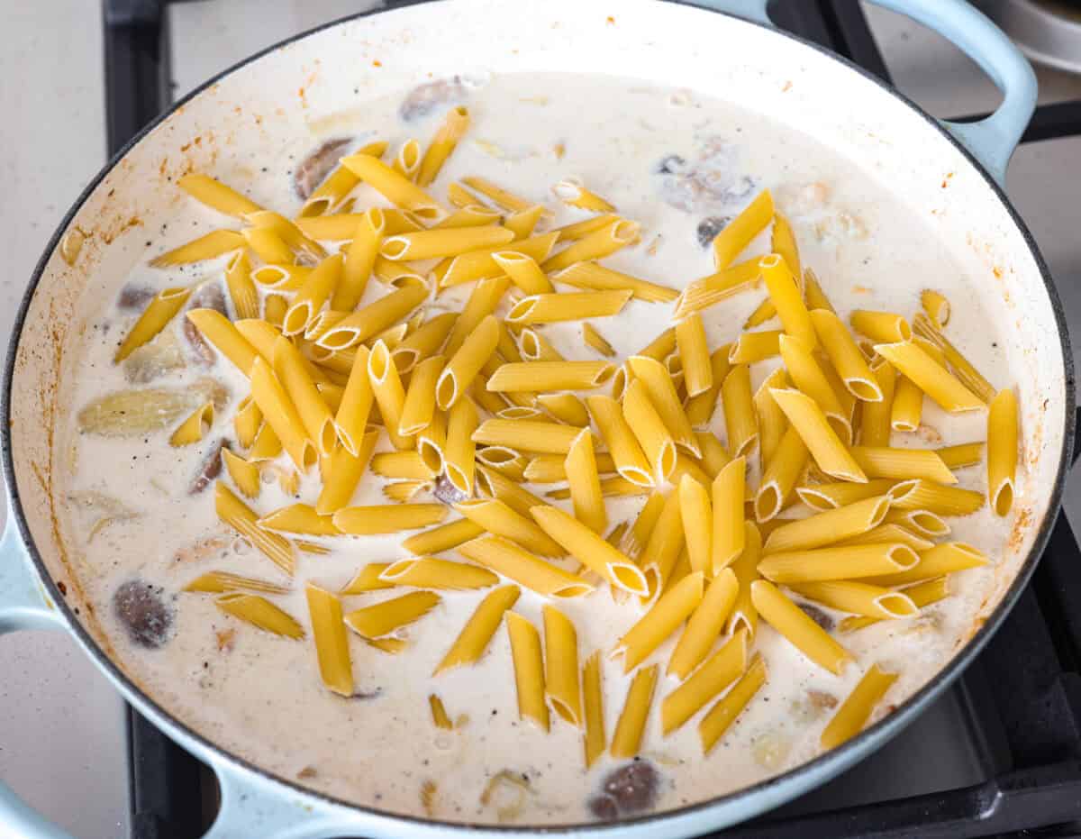 Creamy Spinach Mushroom Artichoke Chicken comes together in just 30 minutes with only one pot! It's a rich, flavorful meal I know you guys will love! Pasta added to the skillet with sauce and chicken mixture.