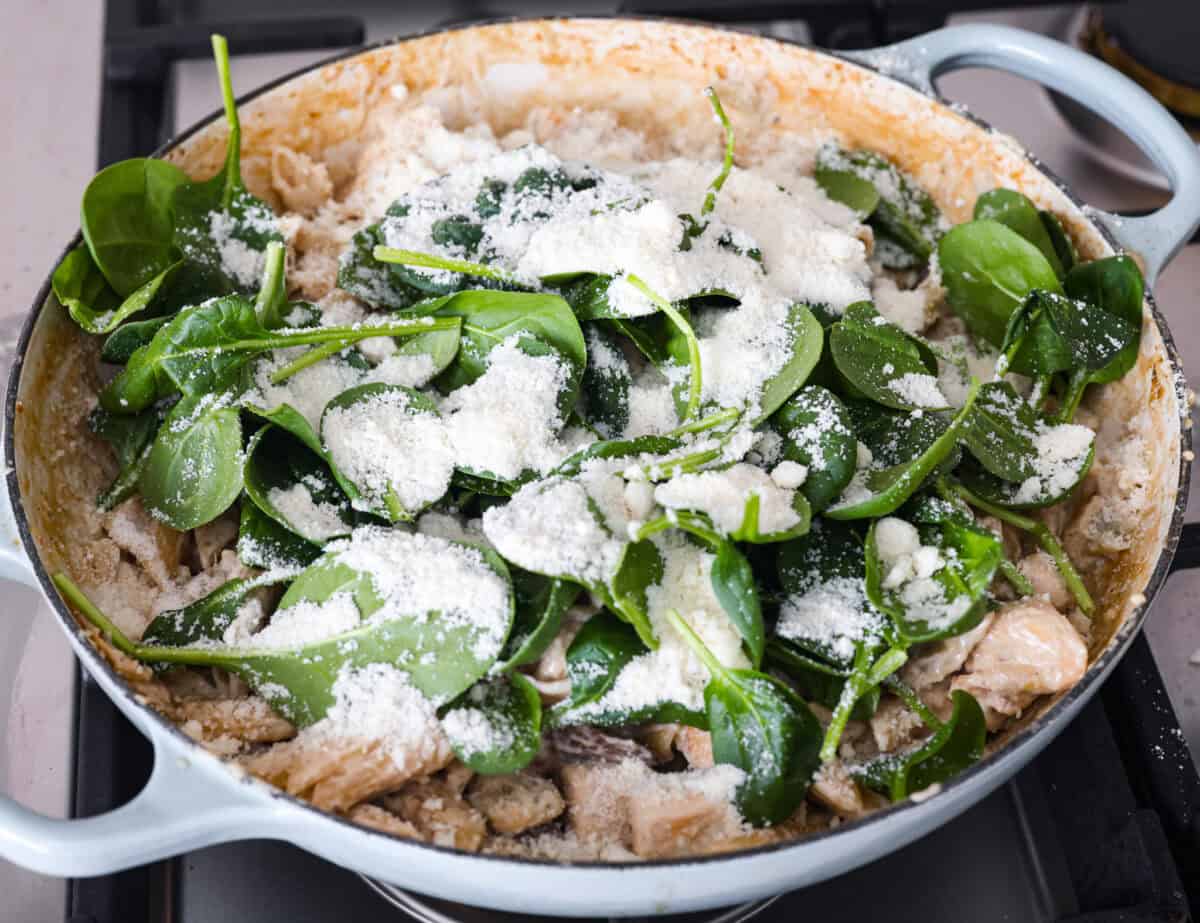 Creamy Spinach Mushroom Artichoke Chicken comes together in just 30 minutes with only one pot! It's a rich, flavorful meal I know you guys will love! Creamy spinach mushroom artichoke chicken with spinach and cheese on top.