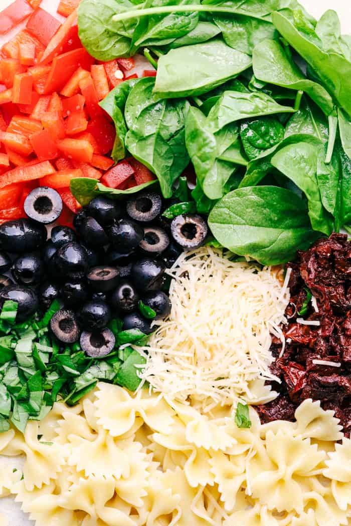 Tuscan Pasta Salad is an easy pasta salad with sun dried tomatoes, peppers spinach, and olives tossed in a tangy dressing. This pasta salad is perfect for your next potluck!ย Tuscan Pasta Salad ingredients.