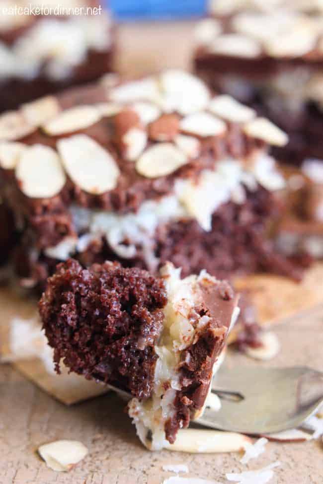 Almond Joy Poke Cake has all of the things that you love about an almond joy candy bar turned into a decadent cake! This cake is irresistible and will satisfy your chocolate craving! Almond Joy Poke Cake bite on a fork.