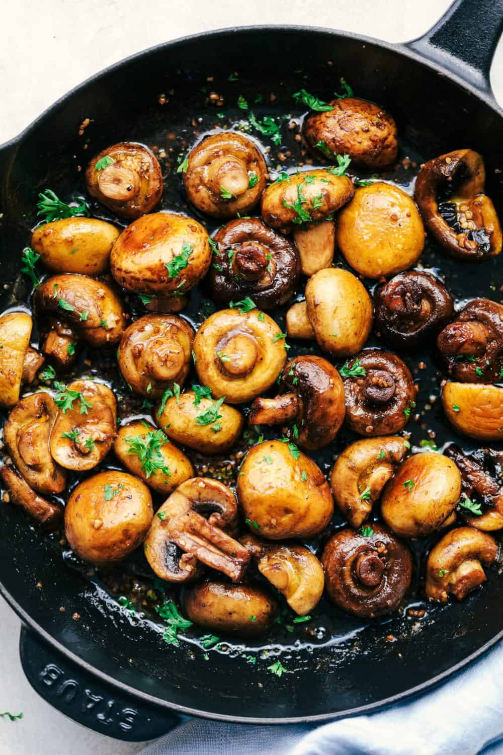 Honey Balsamic Garlic Mushrooms are sautรฉed in the most incredible honey balsamic garlic sauce. This makes an excellent topping for steak or chicken or is even great as a side dish!ย Honey Balsamic Garlic Mushrooms in a black skillet.