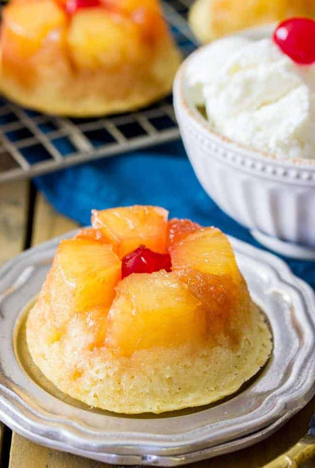 Sweet and simple pineapple upside down-cupcakes made entirely from scratch (donโt worry, theyโre easy!). With fluffy vanilla cupcake bases topped off with caramelized pineapple and maraschino cherries, these are a great new way to enjoy a classic recipe! Easy, from-scratch, pineapple upside-down cupcake on a plate.