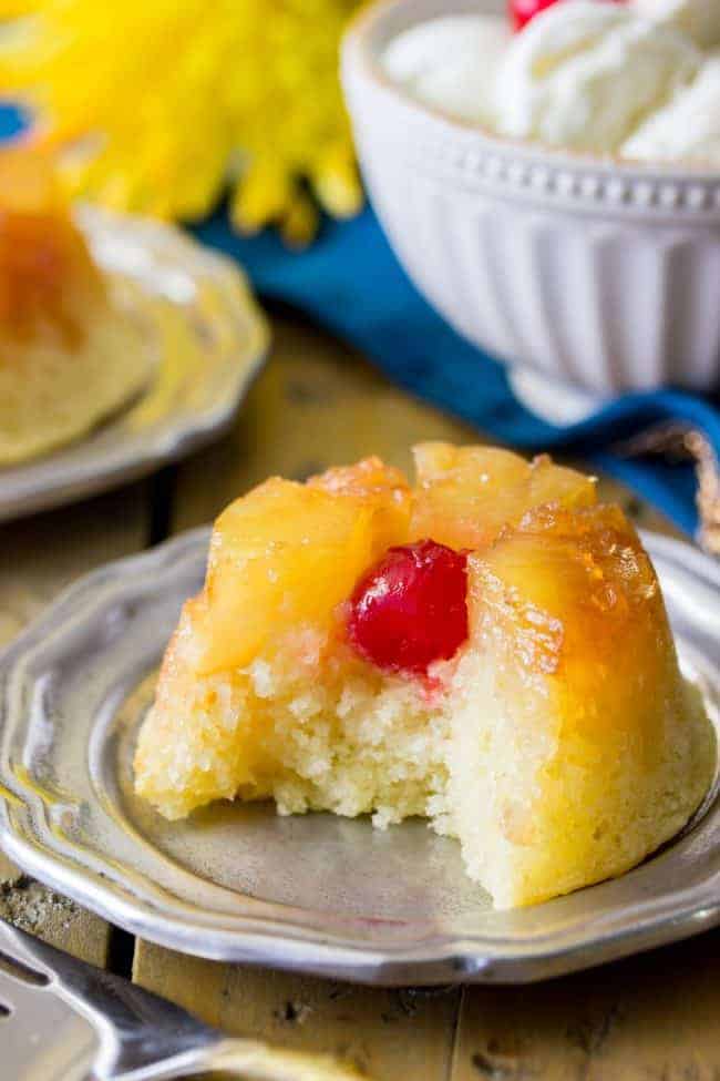 Sweet and simple pineapple upside down-cupcakes made entirely from scratch (donโt worry, theyโre easy!). With fluffy vanilla cupcake bases topped off with caramelized pineapple and maraschino cherries, these are a great new way to enjoy a classic recipe! Easy, from-scratch, pineapple upside-down cupcake with a bite out to show the inside of this moist cake.