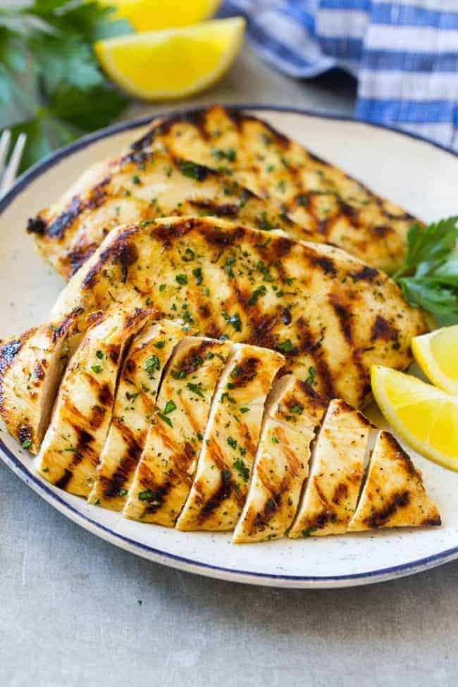 This grilled citrus and herb chicken is juicy, tender, and flavored with the best marinade. A super easy dish that's ready in no time! Sliced grilled citrus and herb chicken on a plate.