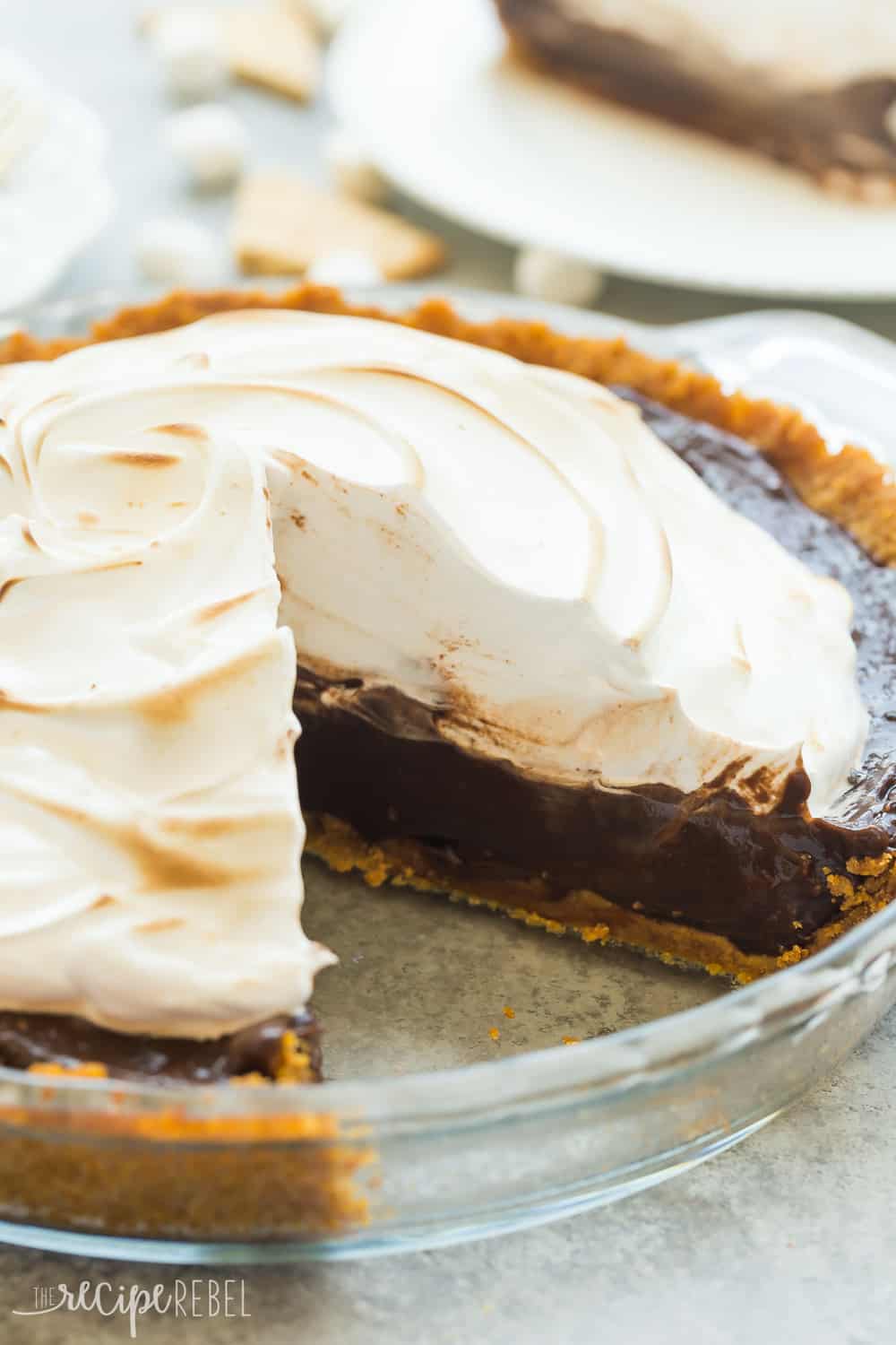 This No Bake S'mores Pie is the easiest summer dessert! A graham cracker crust is loaded with chocolate filling and topped with marshmallow cream! No Bake S'mores Pie with one slice missing.