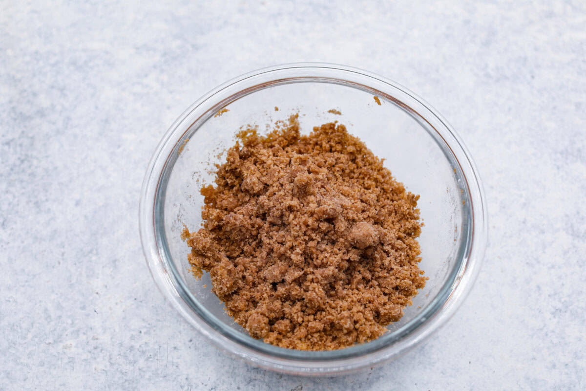 Apple Crumb Muffins are sweet and fluffy bakery-style muffins topped with a brown sugar crumble.ย Every bite is loaded with fresh apple pieces and spiced to perfection! Fifth photo of the apple crumb topping mixed in a bowl.