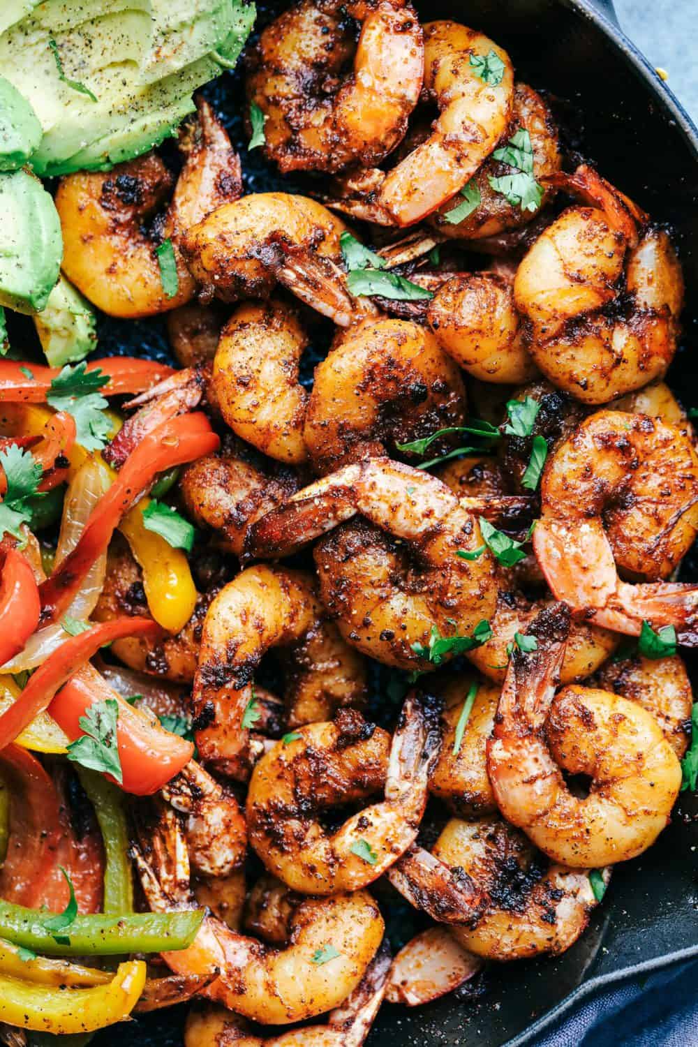 20 Minute Skillet Blackened Shrimp Fajitas are such an easy and flavorful meal packed with blackened shrimp, peppers and onion. This classic meal is perfect served up in tortillas with avocado and chopped cilantro! 20 Minute Skillet Blackened Shrimp Fajitas in a skillet.