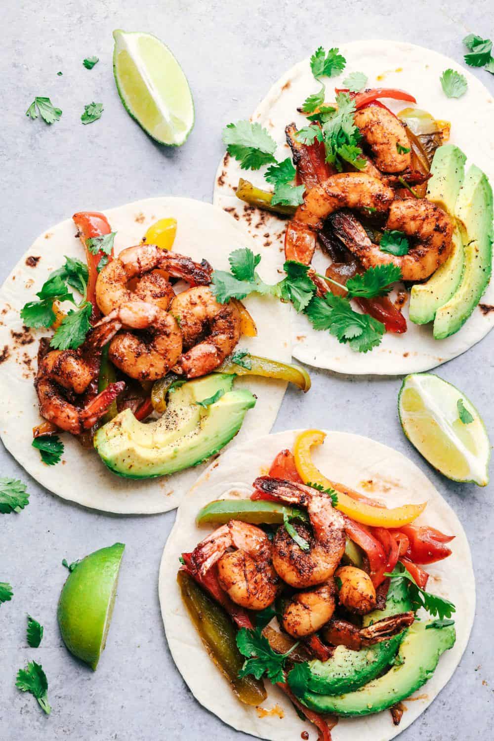 20 Minute Skillet Blackened Shrimp Fajitas are such an easy and flavorful meal packed with blackened shrimp, peppers and onion. This classic meal is perfect served up in tortillas with avocado and chopped cilantro! 20 Minute Skillet Blackened Shrimp Fajitas opened up to show the ingredients inside.