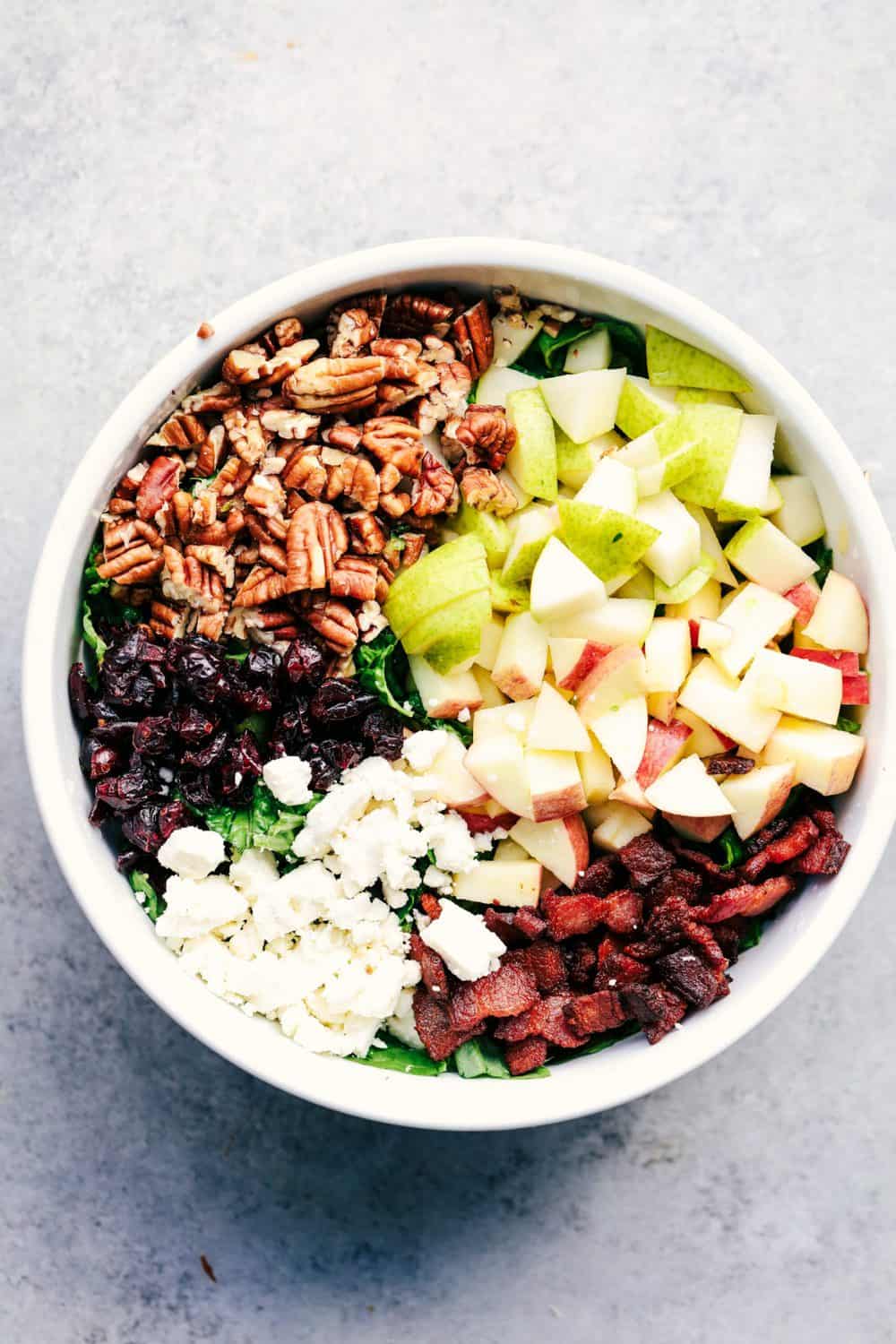 Autumn Chopped Salad with Creamy Poppyseed Dressing is all of your fall salad dreams come true! Crisp chopped apples, pears, romaine lettuce, crunchy pecans, bacon, cranberries and feta cheese combine in a creamy dressing to bring you one unforgettable salad!ย Autumn Chopped Salad with Creamy Poppyseed Dressing in bowl,