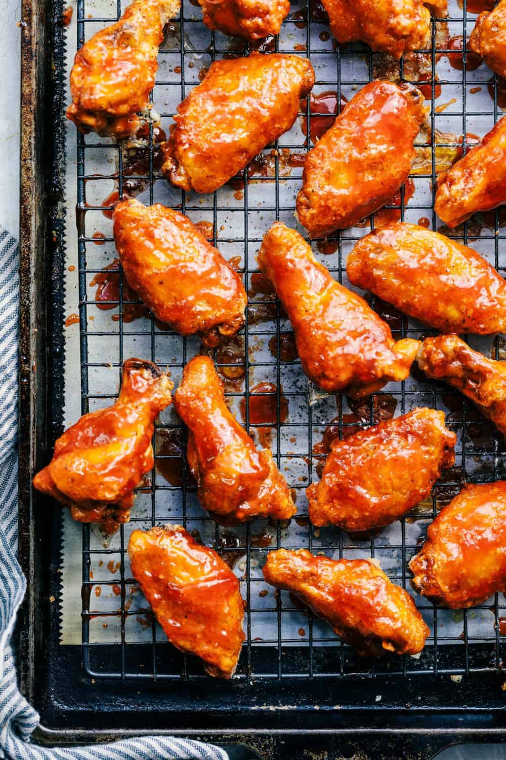 Baked Sticky Honey Garlic Buffalo Wings are baked to crispy perfection and topped with the most amazing honey garlic buffalo sauce. These are finger licking good! Baked Sticky Honey Garlic Buffalo Wings on a cooling rack.