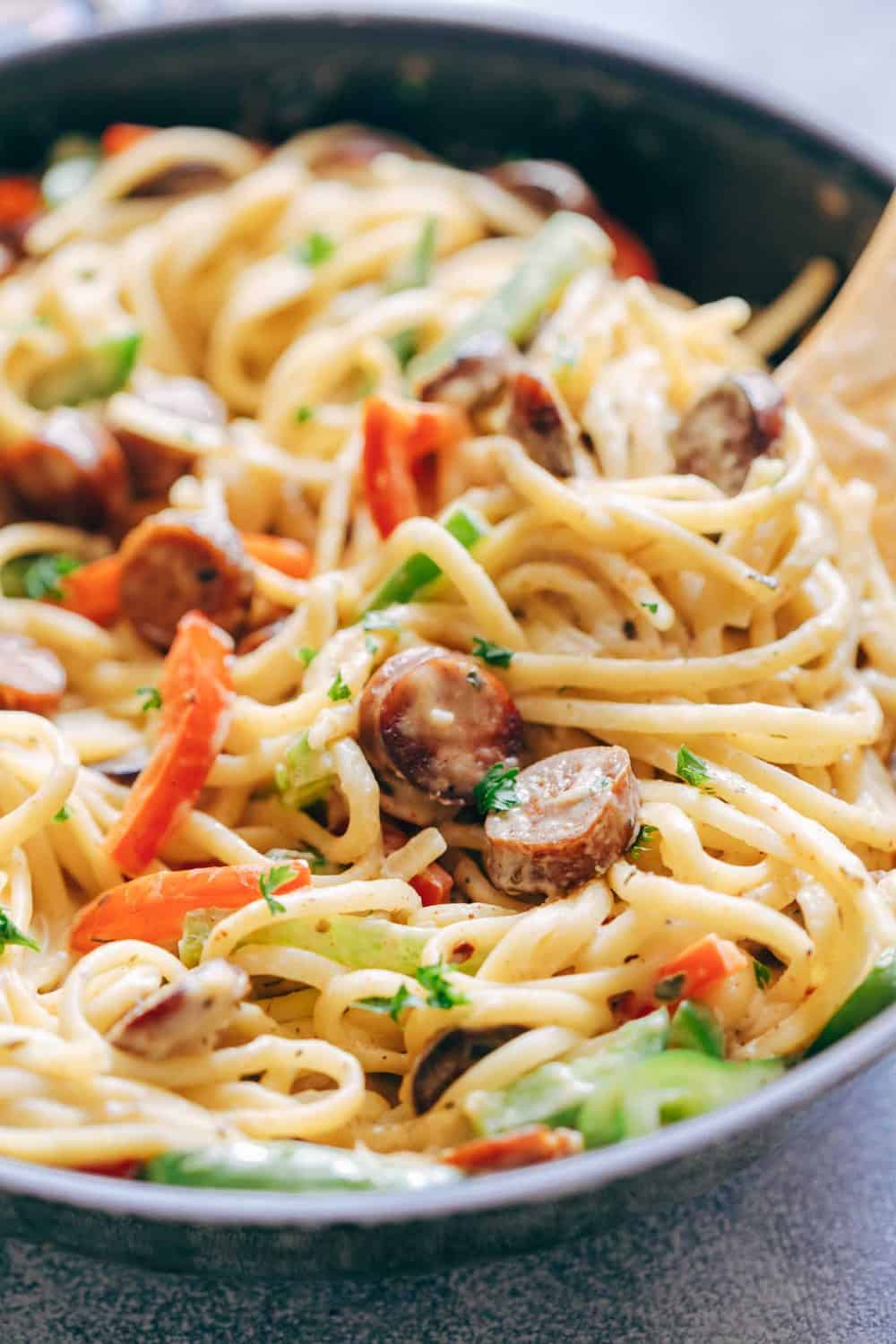 Creamy Cajun Sausage Linguine is a creamy 30 minute pasta recipe that's going to become a family favourite! Not too heavy on the cheese but still super creamy! Creamy Cajun Sausage Linguine close up in a skillet.
