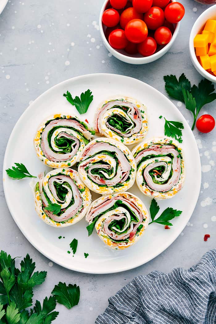 Turkey Bacon Ranch Pinwheels are an easy wrap with turkey, bacon, ranch and cheese and are perfect for an appetizer or lunch! They are delicious served hot or cold and are sure to please your tastebuds. Turkey Bacon Ranch Pinwheels on a white plate.