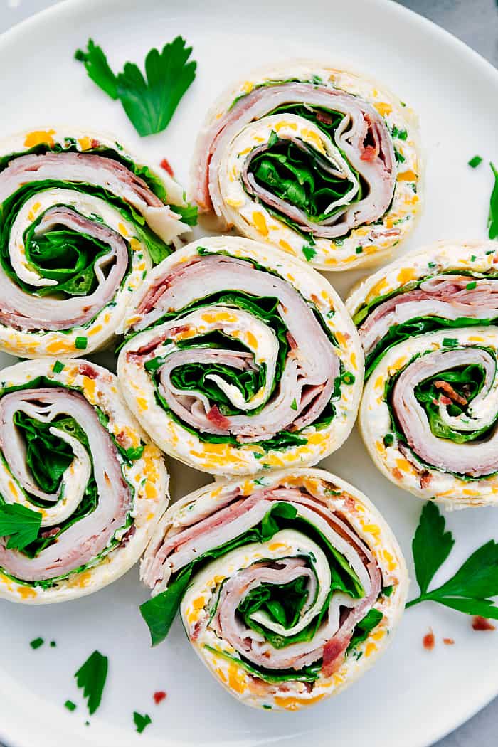 Turkey Bacon Ranch Pinwheels are an easy wrap with turkey, bacon, ranch and cheese and are perfect for an appetizer or lunch! They are delicious served hot or cold and are sure to please your tastebuds. Turkey Bacon Ranch Pinwheels on a white plate.