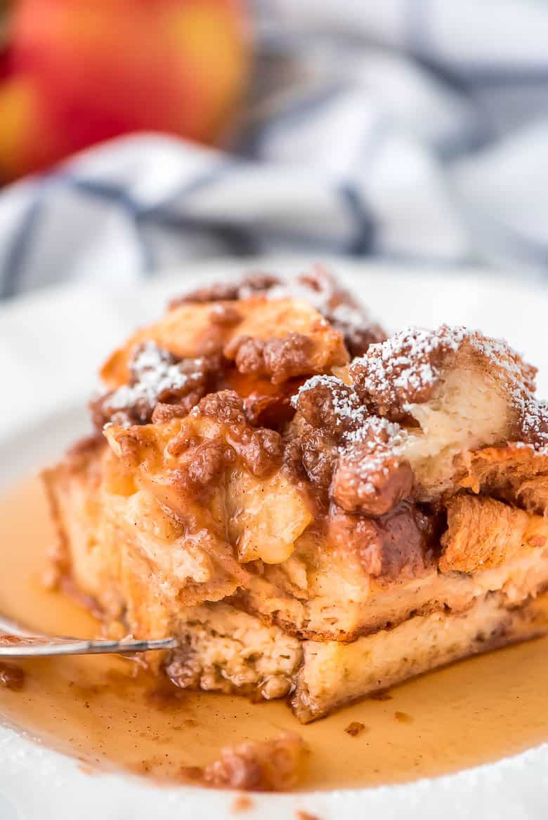 Overnight Cinnamon Apple French Toast Casserole is the perfect autumn breakfast to wake the family up to!ย Overnight Cinnamon Apple French Toast Casserole on a white plate.