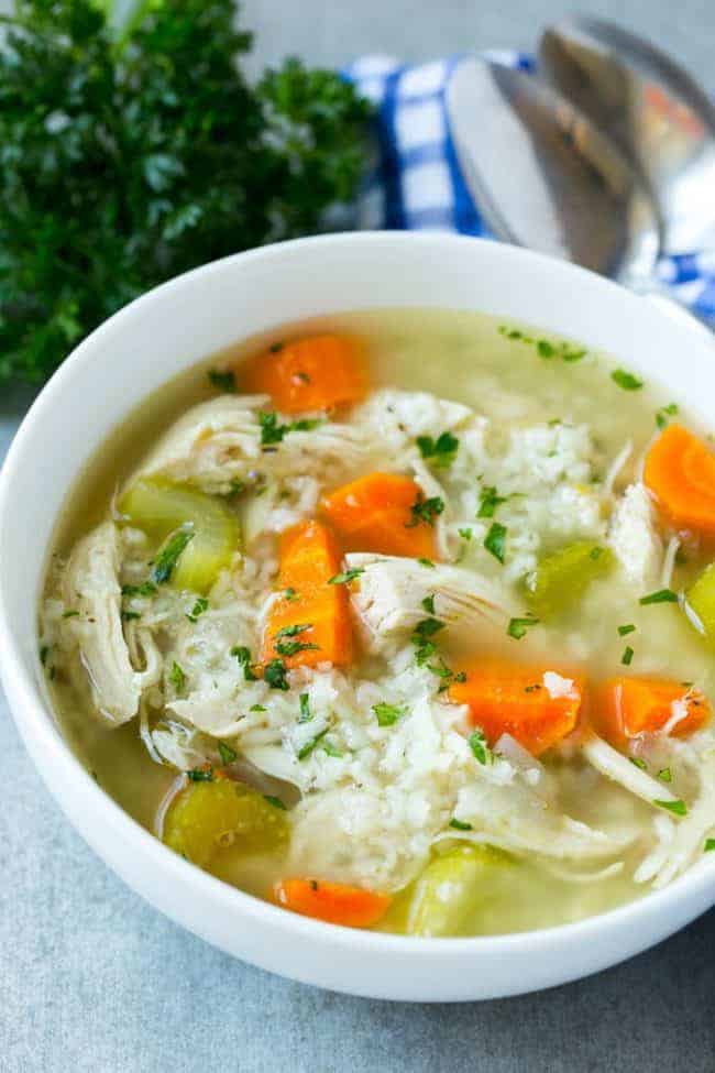 This slow cooker chicken and rice soup is an easy and comforting meal that's perfect for cold nights! This slow cooker chicken and rice soup in a white bowl.