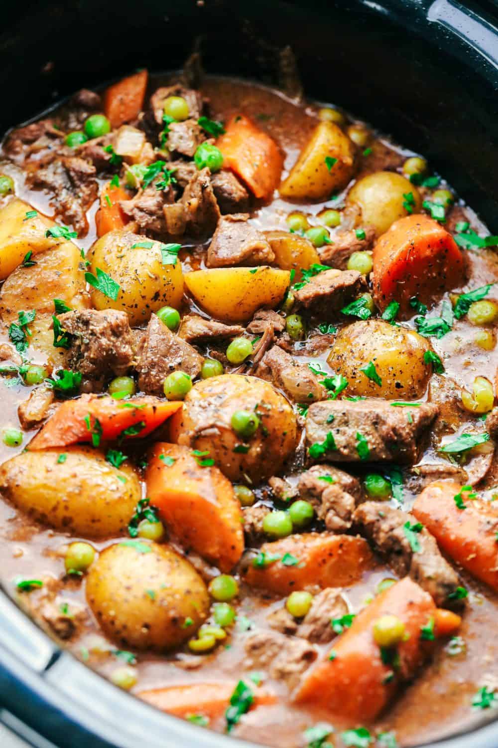 Best Ever Slow Cooker Beef Stew is the absolute perfect comforting beef stew. A thick and rich sauce filled with hearty and chunky potatoes, carrots, onions, and peas with the most amazing tender melt in your mouth beef! Best Ever Slow Cooker Beef Stew in a slow cooker.