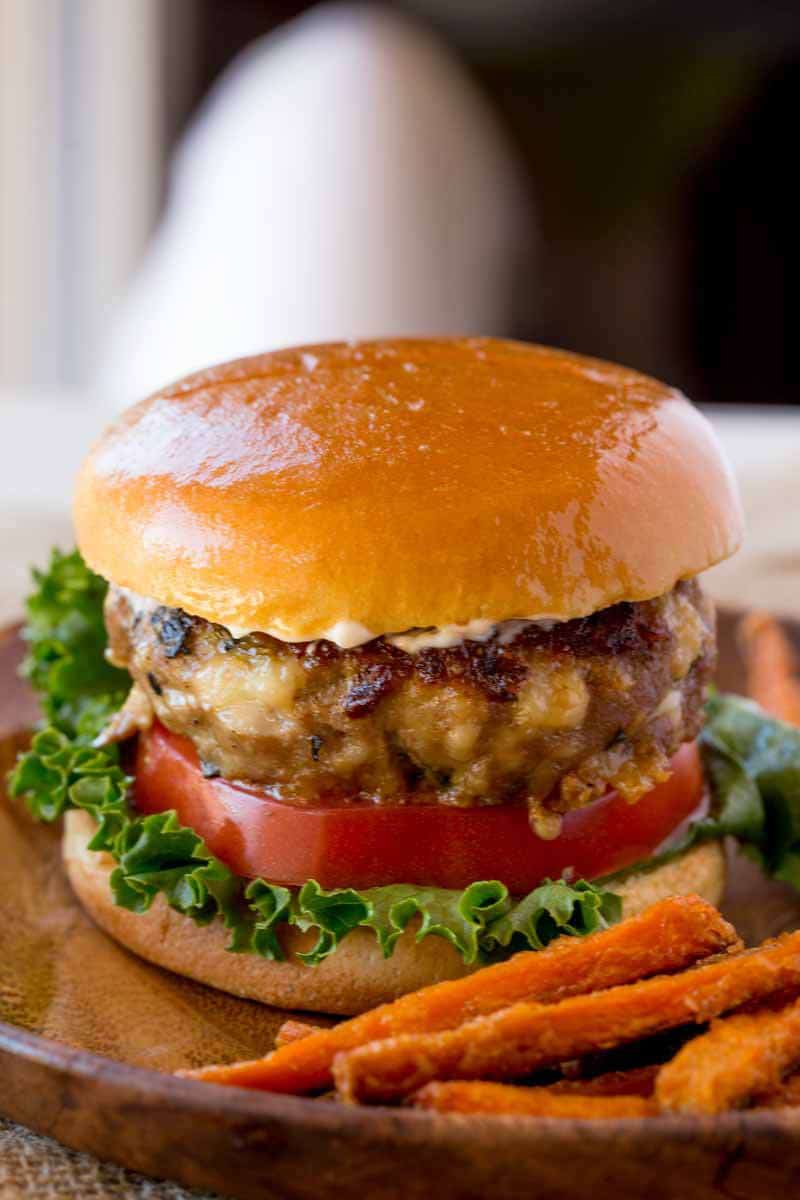 Spinach Feta Turkey Burgers with fresh spinach, salty crumbled feta cheese and a super tender turkey patty topped with lemony greek yogurt. Spinach Feta Turkey Burger from the side.