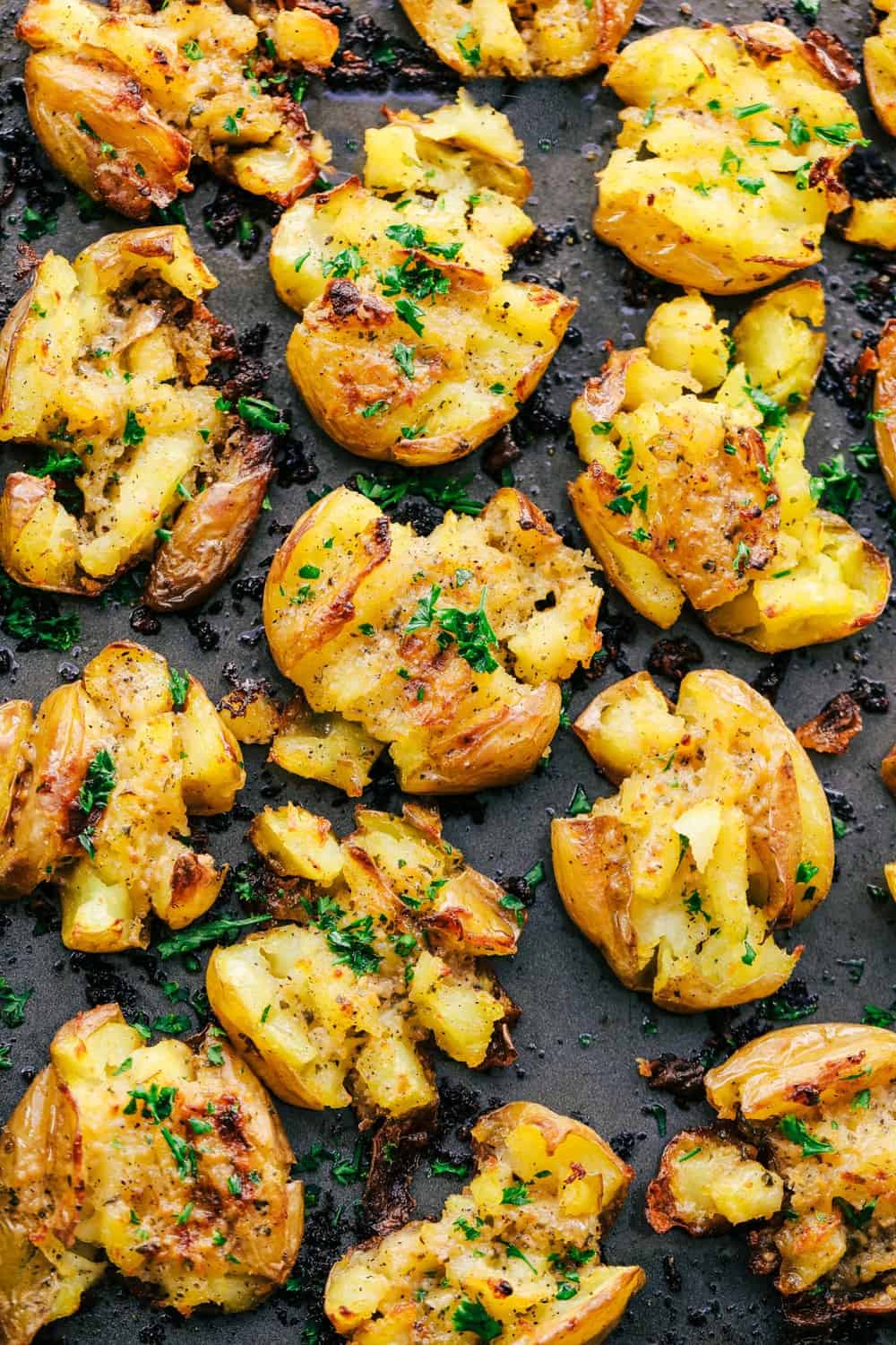 Garlic Ranch Smashed Potatoes are crispy on the outside and tender on the inside with the most incredible garlic ranch flavor! These make the perfect side dish or appetizer. Garlic Ranch Smashed Potatoes on a sheet pan.