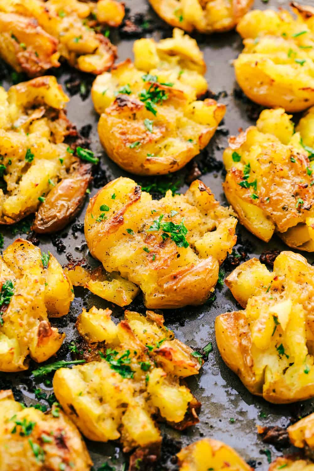 Garlic Ranch Smashed Potatoes are crispy on the outside and tender on the inside with the most incredible garlic ranch flavor! These make the perfect side dish or appetizer. Garlic Ranch Smashed Potatoes on a pan.