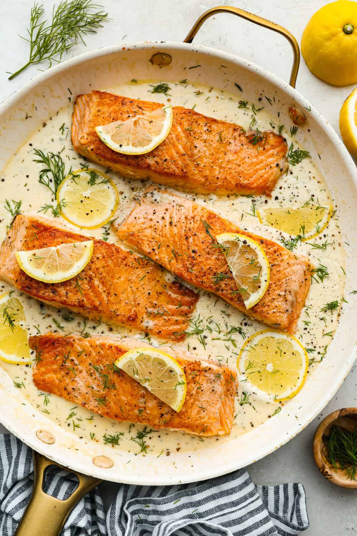 Overhead shot of pan seared salmon in creamy lemon dill sauce.