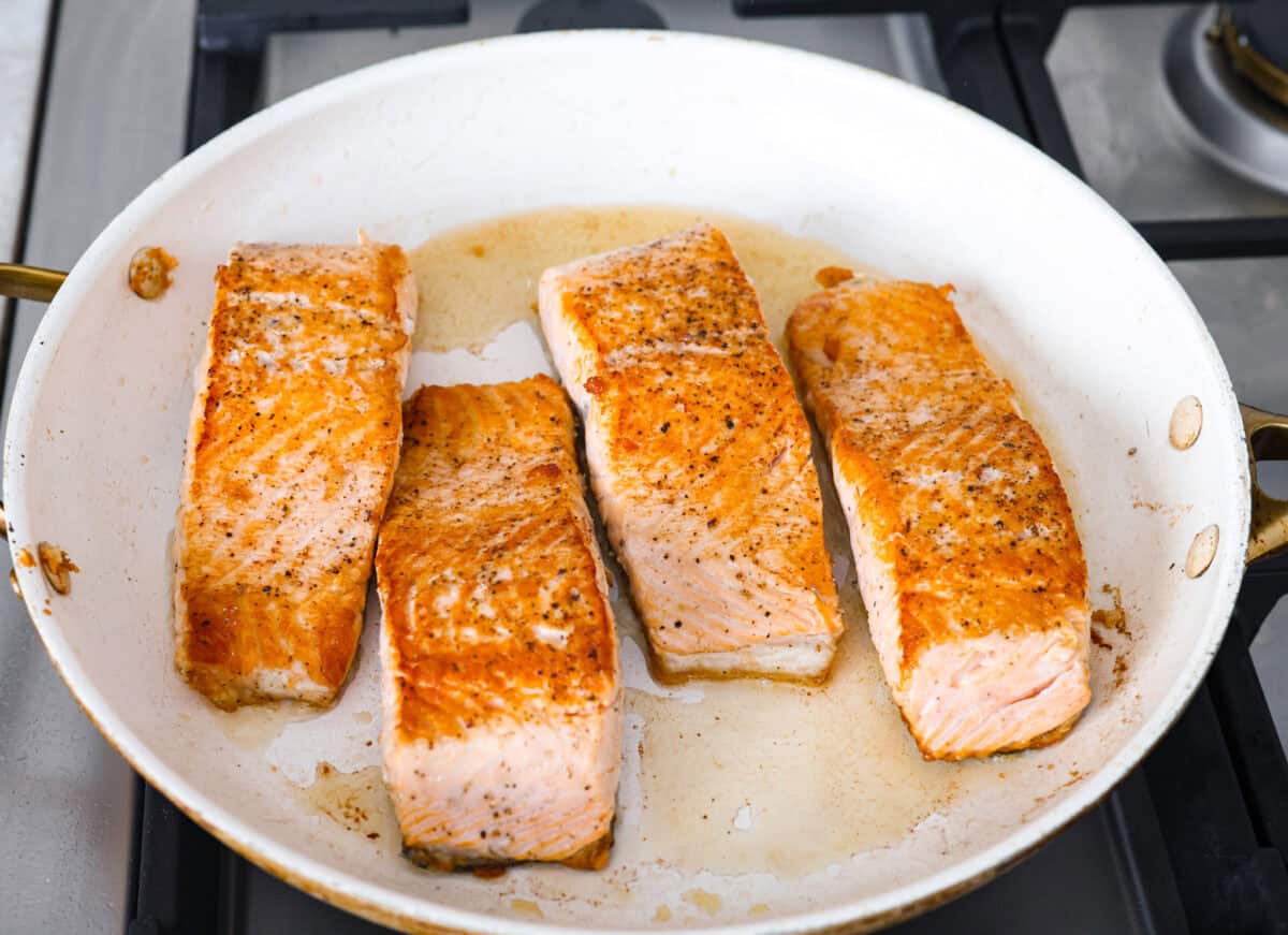 My Pan Seared Salmon has a new and improved Sauce! I added salt to bring out the flavors, and now it’s perfect! Fresh lemon juice and dill make it a match made in salmon heaven! Salmon searing in a pan.
