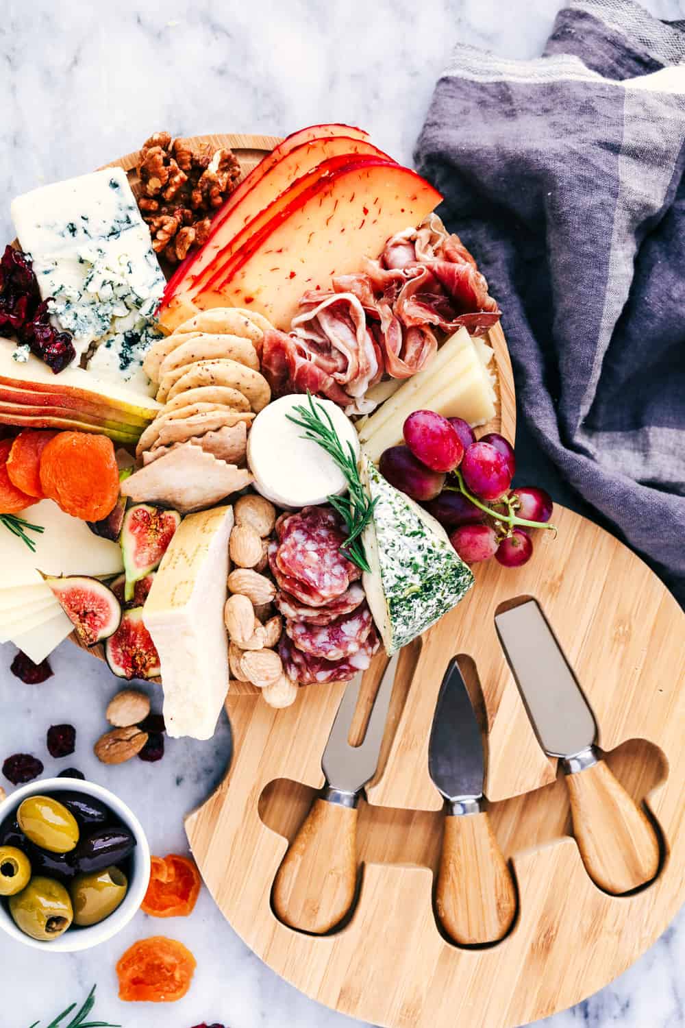 How to Make an Easy Cheese Board filled with meats, cheeses, nuts, and fruit. This makes a beautifulย presentation at any gathering!ย Easy Cheese Board ingredients.