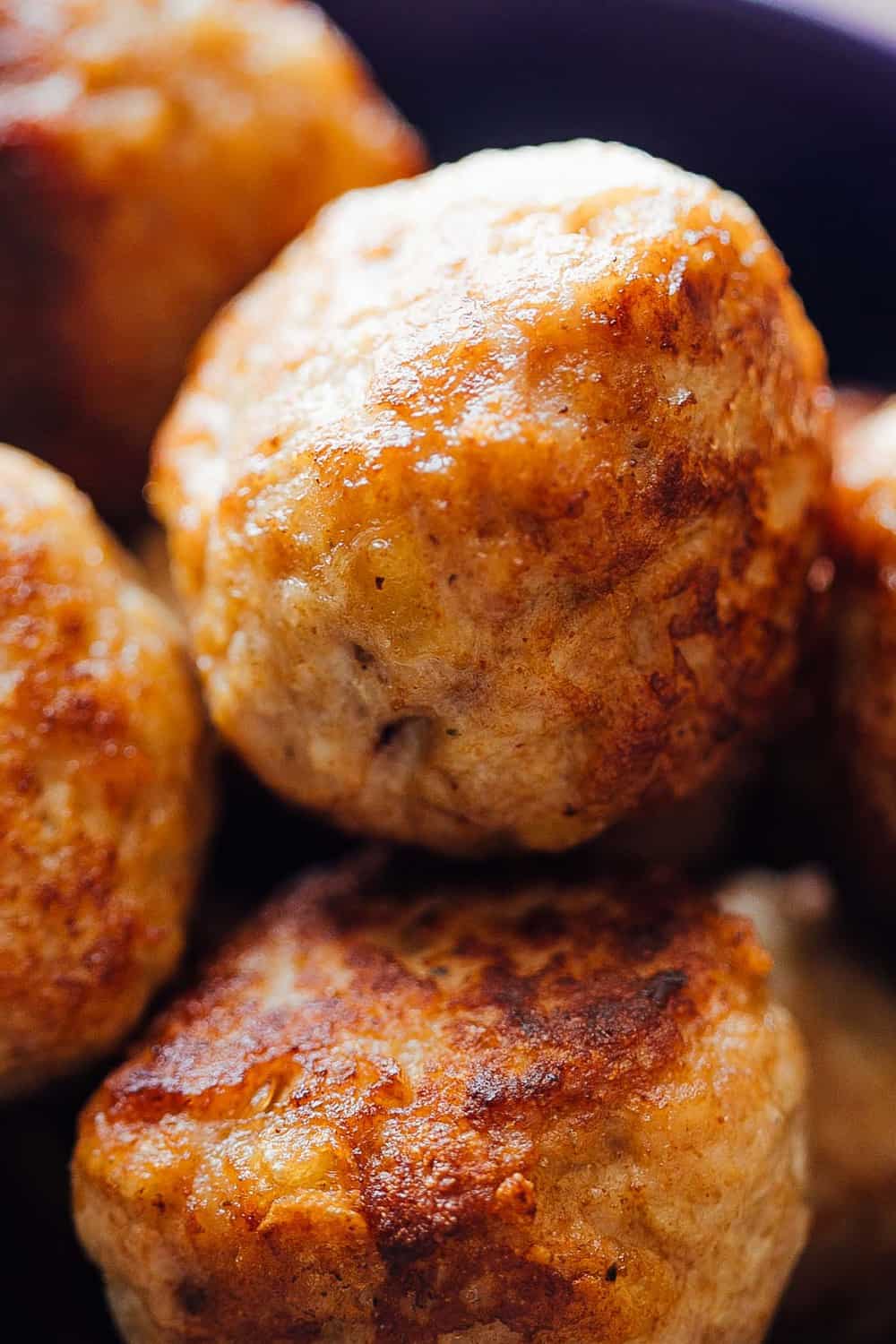 Creamy Cajun Chicken Meatballs are soft, juicy chicken meatballs slathered in a creamy gravy flavoured with cajun seasoning. This one-pot recipe is the perfect dinner option! Close up on cooked meatballs.