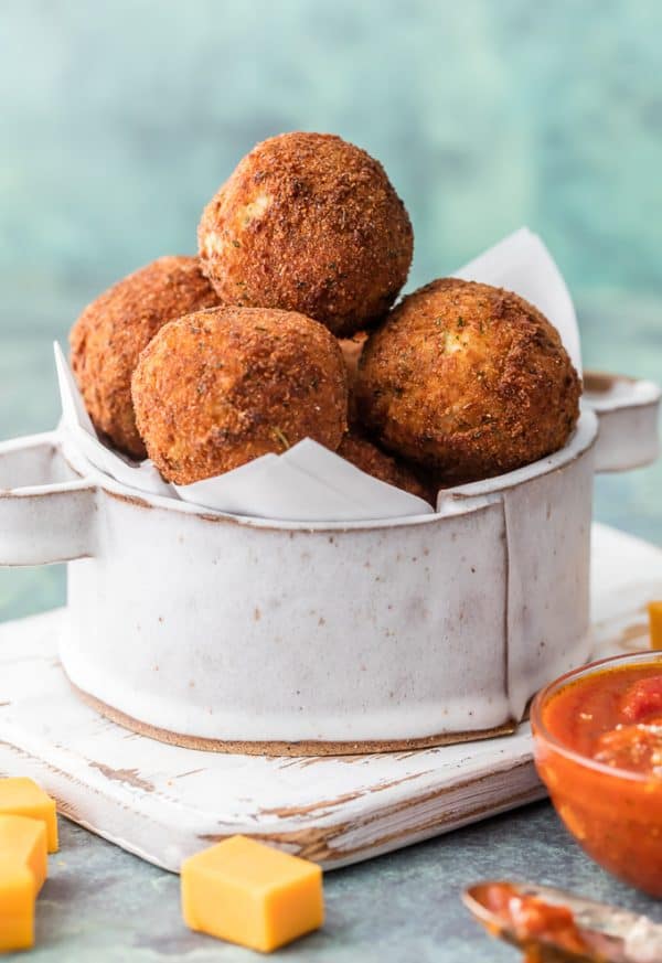 This Bacon Broccoli Cheese Arancini is a fun and unique appetizer fit for starting any delicious meal at home. Much easier than you would think and bursting with flavor. This Bacon Broccoli Cheese Arancini stacked in a pan.