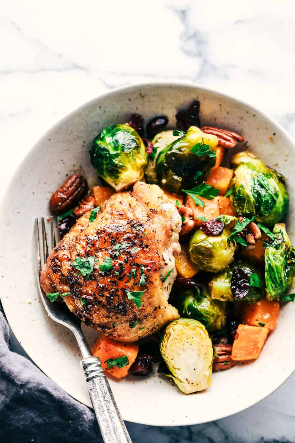 Roasted Honey Garlic Butter Chicken with Brussels Sprouts and Butternut Squash is a rustic and delicious meal that is full of amazing flavor. This is a comforting meal in one that is perfect for feeding your family! roasted honey garlic butter chicken with Brussels sprouts and butternut squash plated