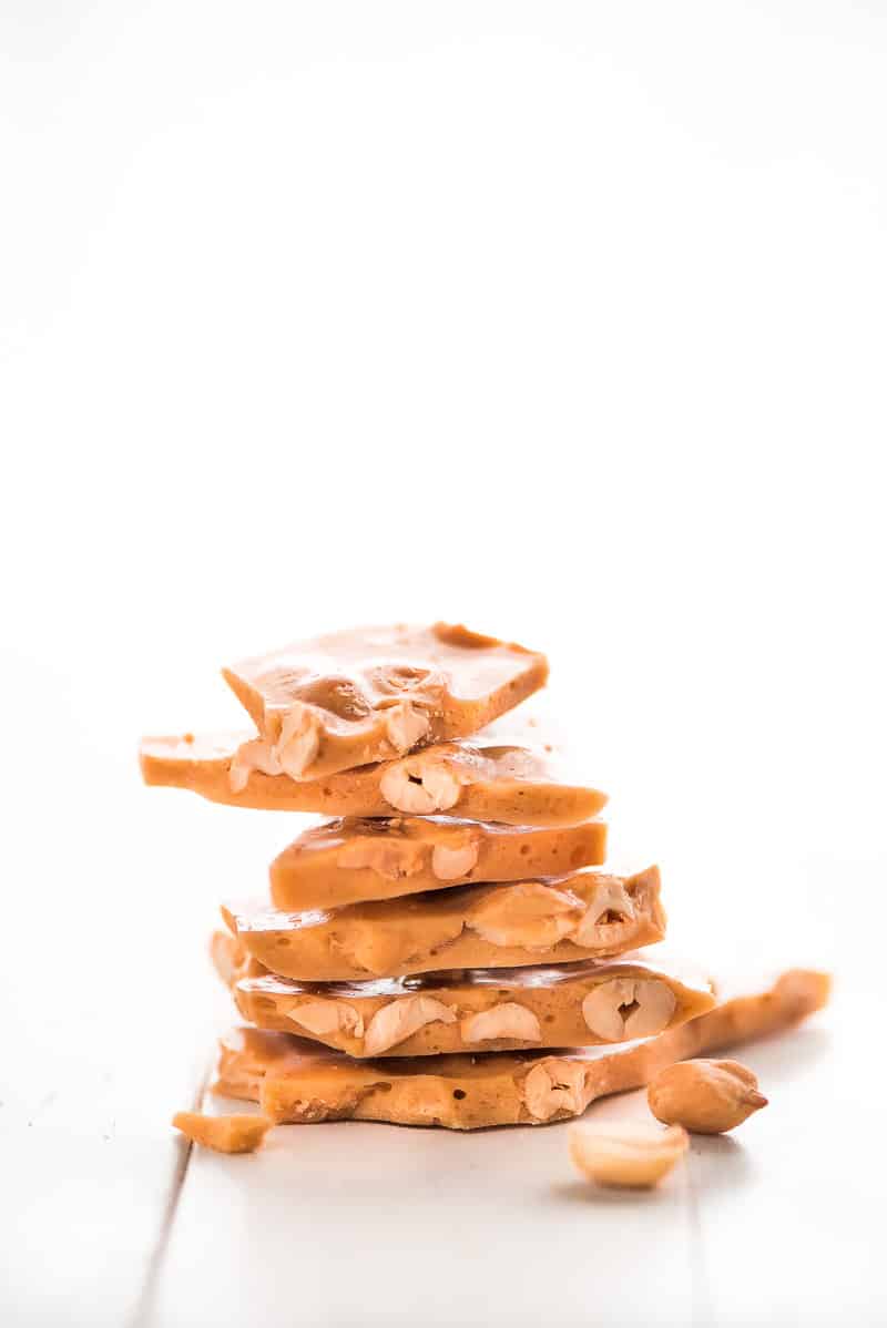 Peanut Brittle is a classic buttery and crunchy candy that no one will be able to resist munching on. It's perfect for packaging and giving away during the holidays. peanut brittle stacked on top of each other