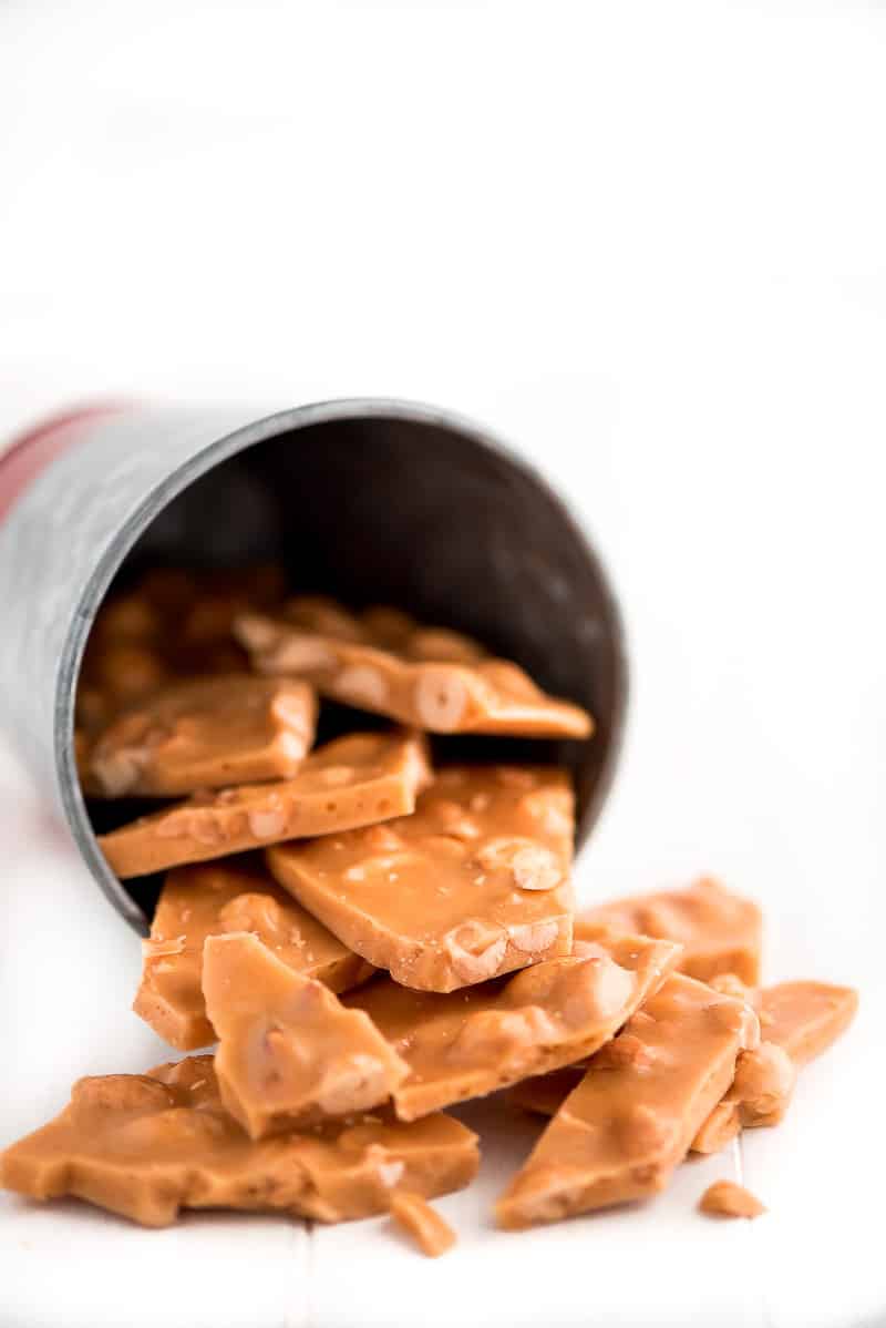 Peanut Brittle is a classic buttery and crunchy candy that no one will be able to resist munching on. It's perfect for packaging and giving away during the holidays. peanut brittle in a jar falling out.
