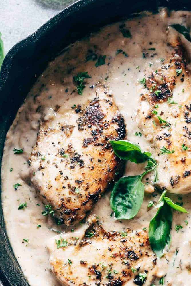 Fast and easy creamy herb chicken takes only 30 minutes to make. This is a delicious recipe that's low on the calories and is creamy but without the heavy cream! Closeup of creamy herb chicken