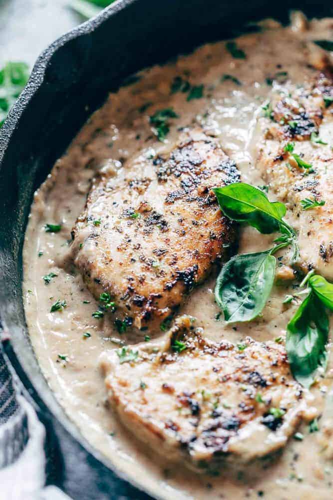 Fast and easy creamy herb chicken takes only 30 minutes to make. This is a delicious recipe that's low on the calories and is creamy but without the heavy cream! Closeup of creamy herb chicken