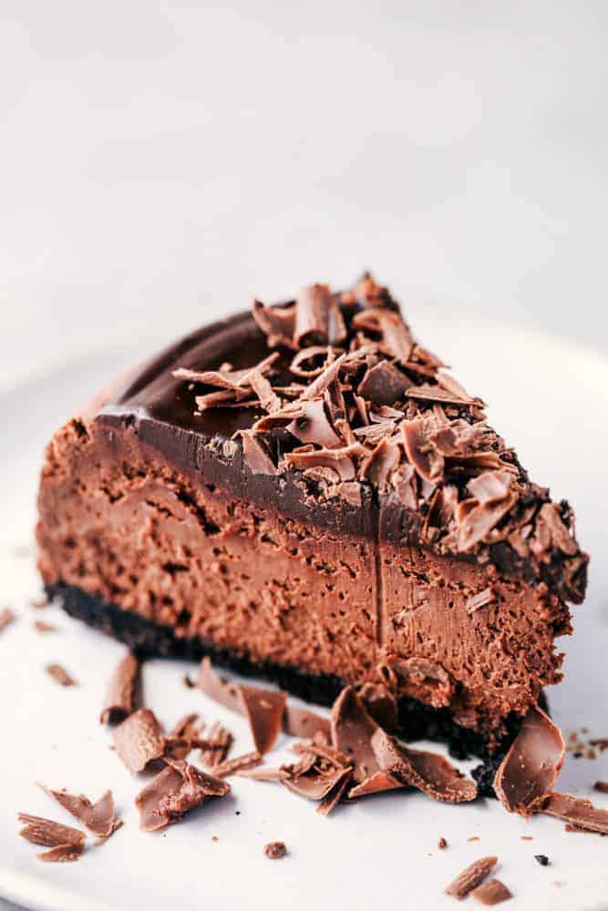 Death by chocolate cheesecake has an Oreo crust with creamy, decadent, and rich chocolate cheesecake. Topped with chocolate ganache, this is a chocolate lover's dream come true! A slice of Death By Chocolate Cheesecake.