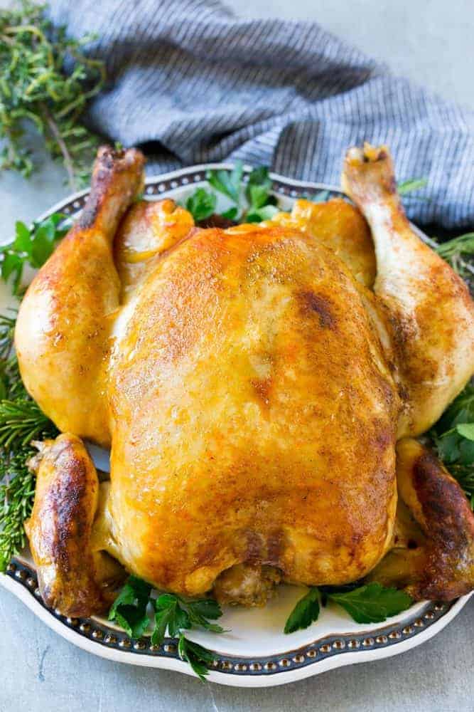 Cooking a whole chicken has never been easier than this Instant Pot roasted chicken! The chicken cooks in just 30 minutes and produces a moist and juicy bird that's the perfect simple dinner option! Cooked whole chicken on a plate.
